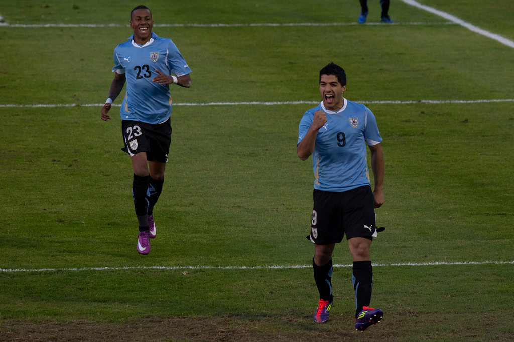 Two soccer players running and smiling.