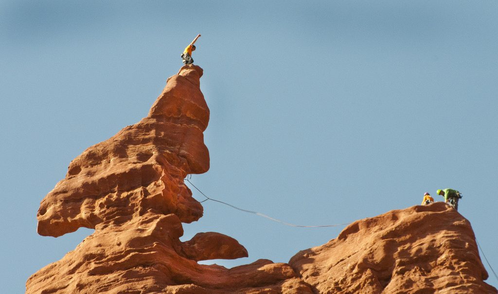 climber makes it to top of tower in Moab and pumps his fist triumphantly